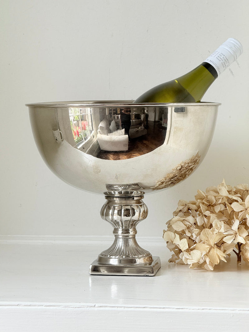Vintage polished metal champagne bowl with pedestal base, photographed on a white surface