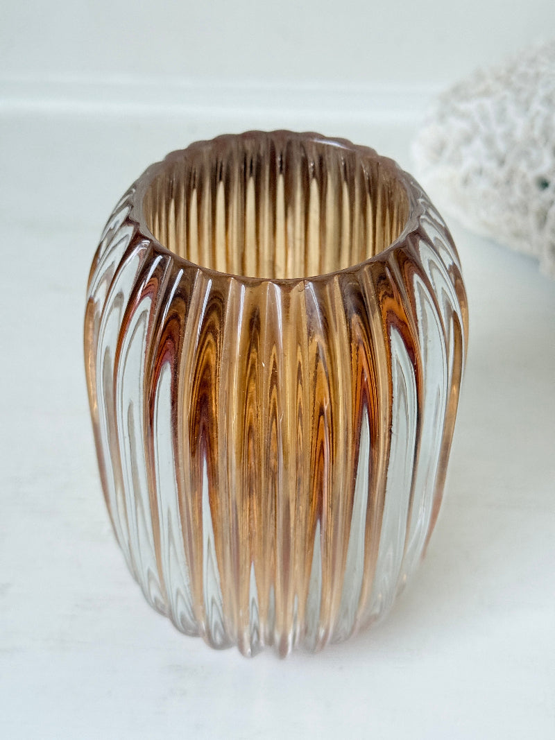 Vintage ribbed amber brown glass vase photographed on a white surface