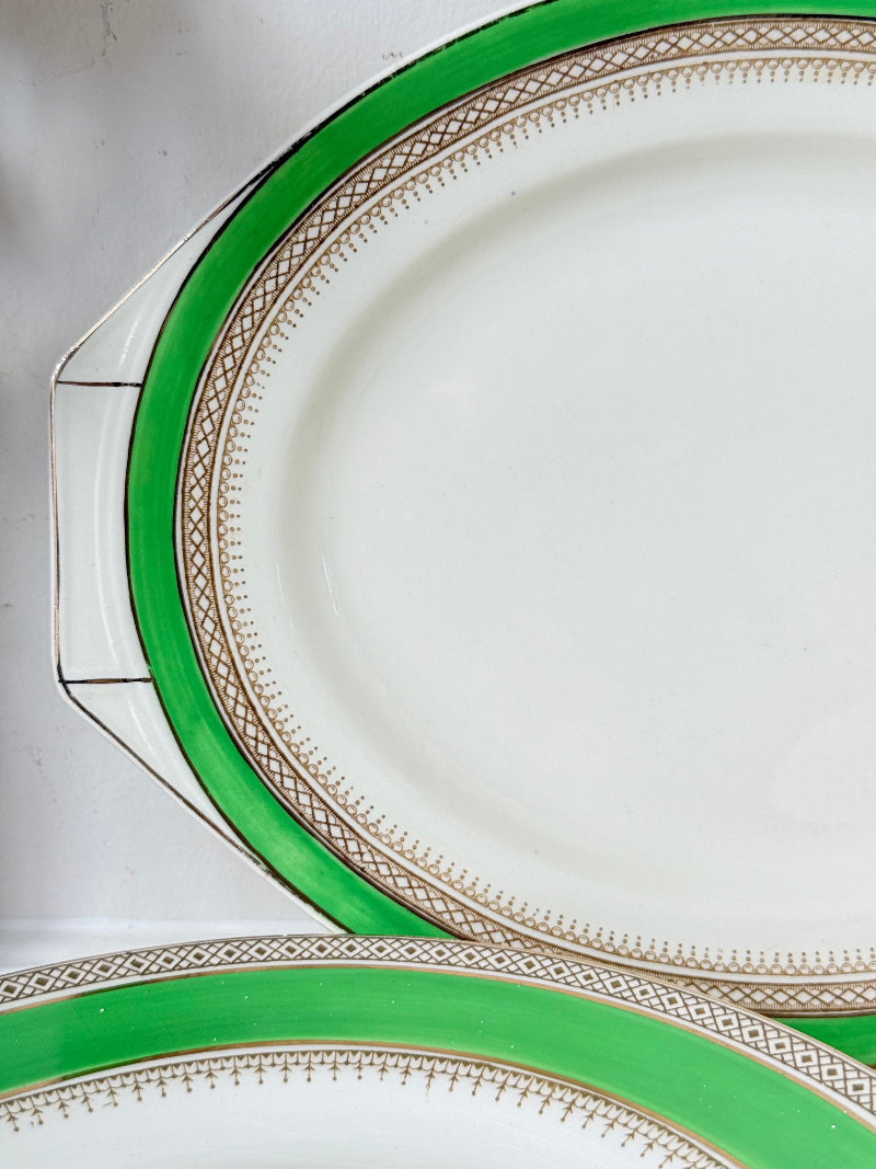 Pair of vintage oval serving platters with bright green Art Deco style border photographed on a white surface