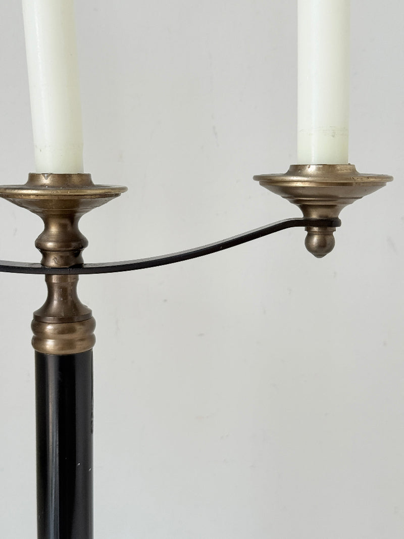 Vintage three arm candelabra in brass and ebonised metal with ivory taper candles styled on a white surface