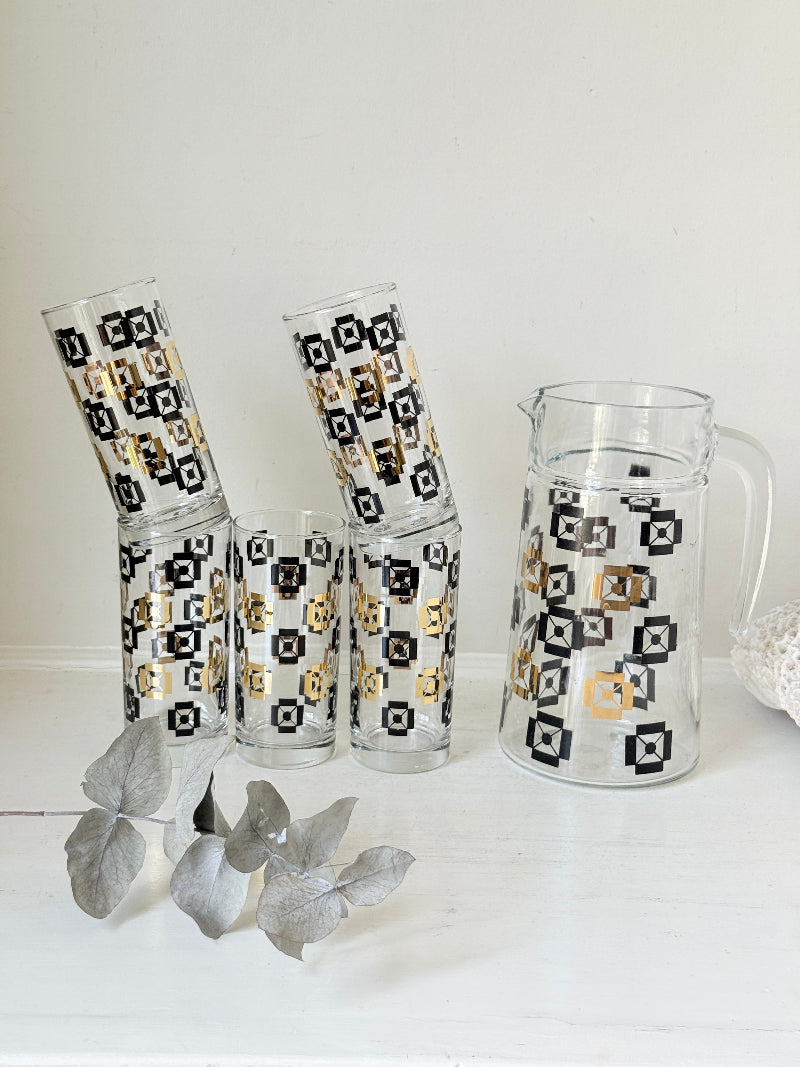 Mid century black and gold glass drinks set with jug and five highball tumblers in a geometric medallion pattern