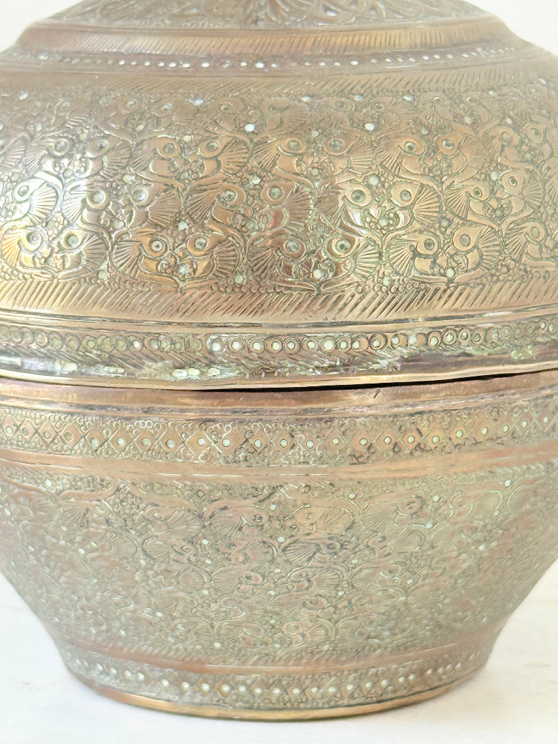 Indian Benares brass lidded jar with floral engraving and finial, photographed on a white surface