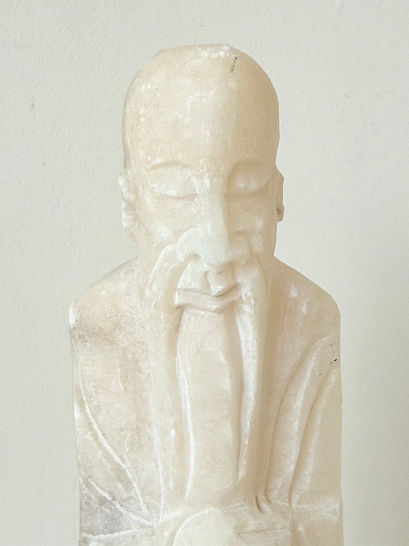 vintage alabaster gentleman figure on square base with carved detail, photographed on white surface with hydrangea flowers.