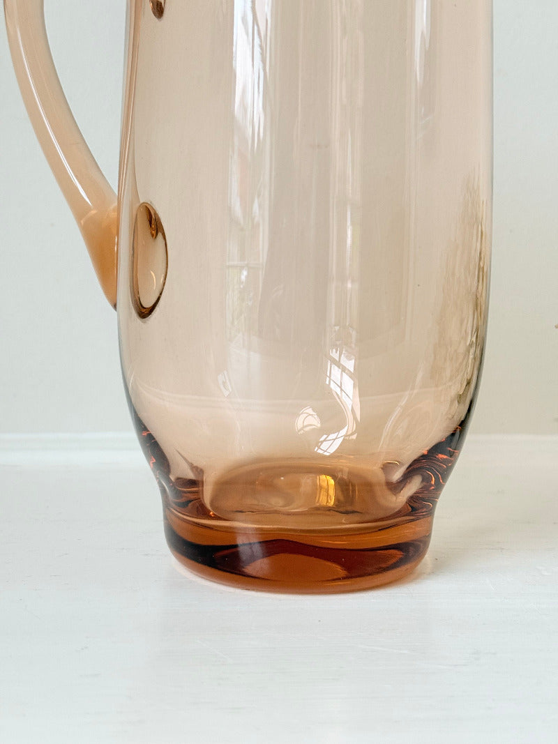 retro apricot glass serving jug with curved handle and flared spout, photographed on white surface