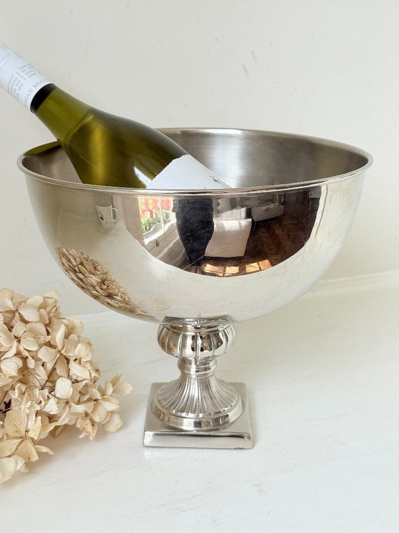 Vintage polished metal champagne bowl with pedestal base, photographed on a white surface