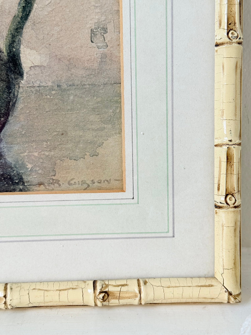 Vintage watercolour of chrysanthemums in green vase, under glass, in cream faux bamboo frame, photographed on white surface.