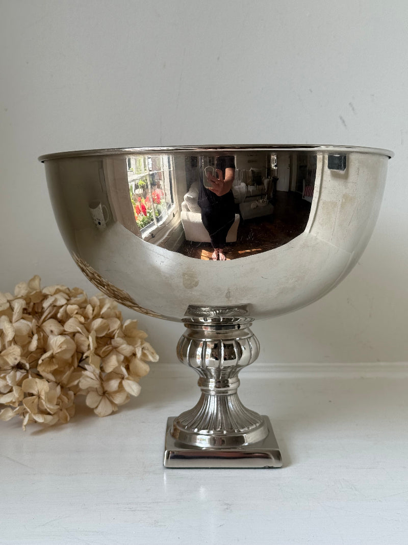 Vintage polished metal champagne bowl with pedestal base, photographed on a white surface
