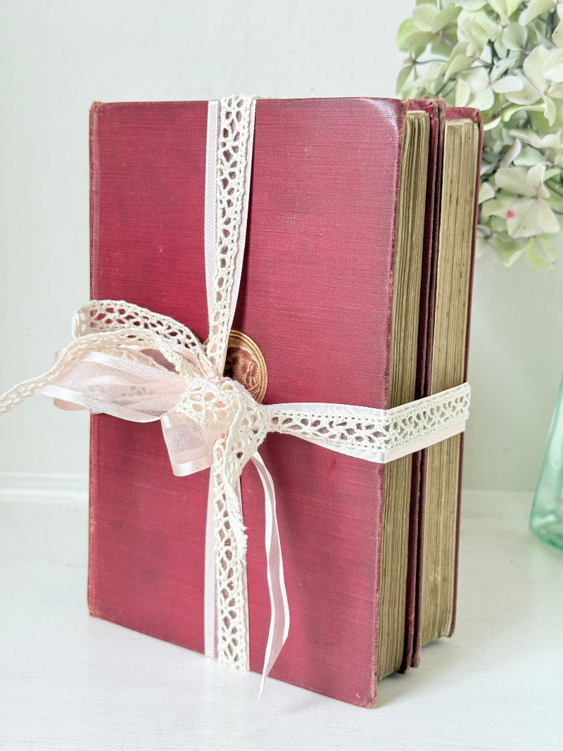 Pair of vintage Rudyard Kipling books in red cloth bindings with gilt lettering, styled as a decorative bundle, photographed on a white surface