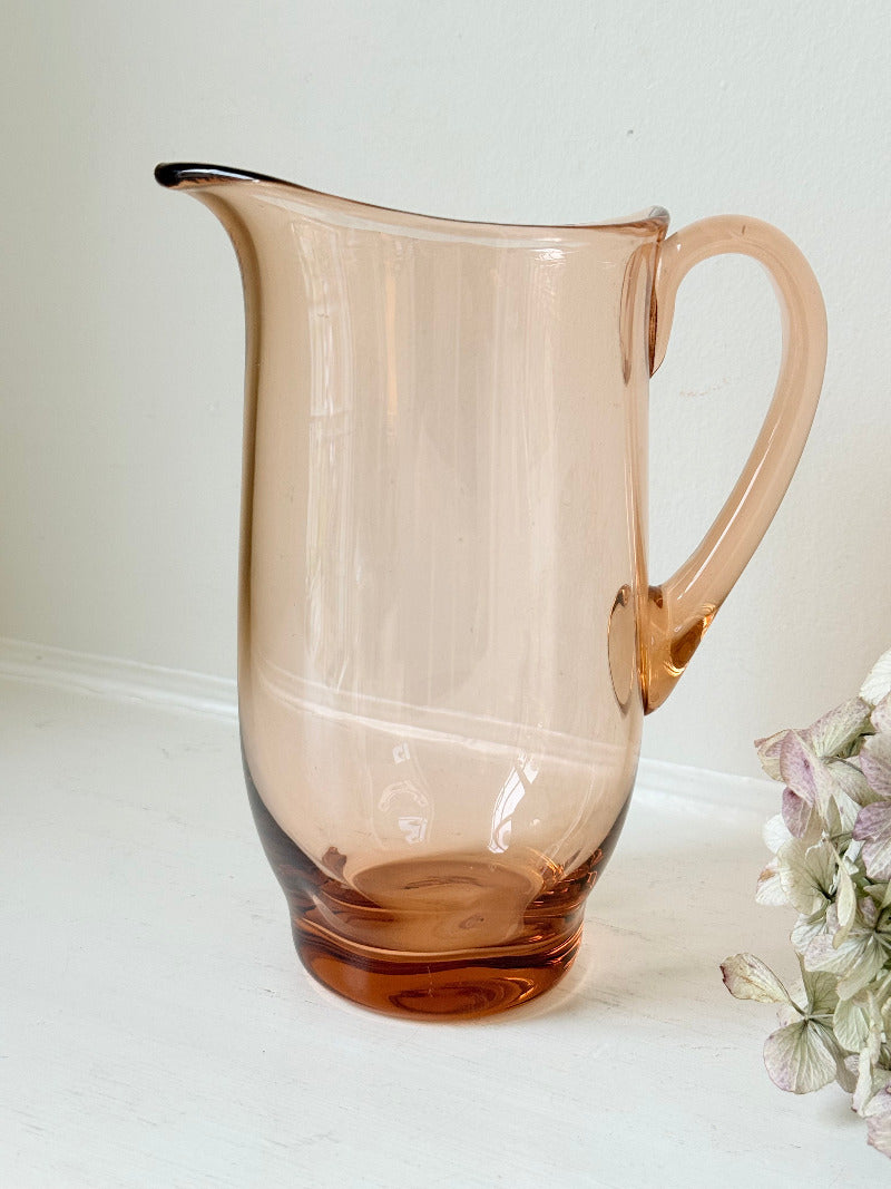 retro apricot glass serving jug with curved handle and flared spout, photographed on white surface
