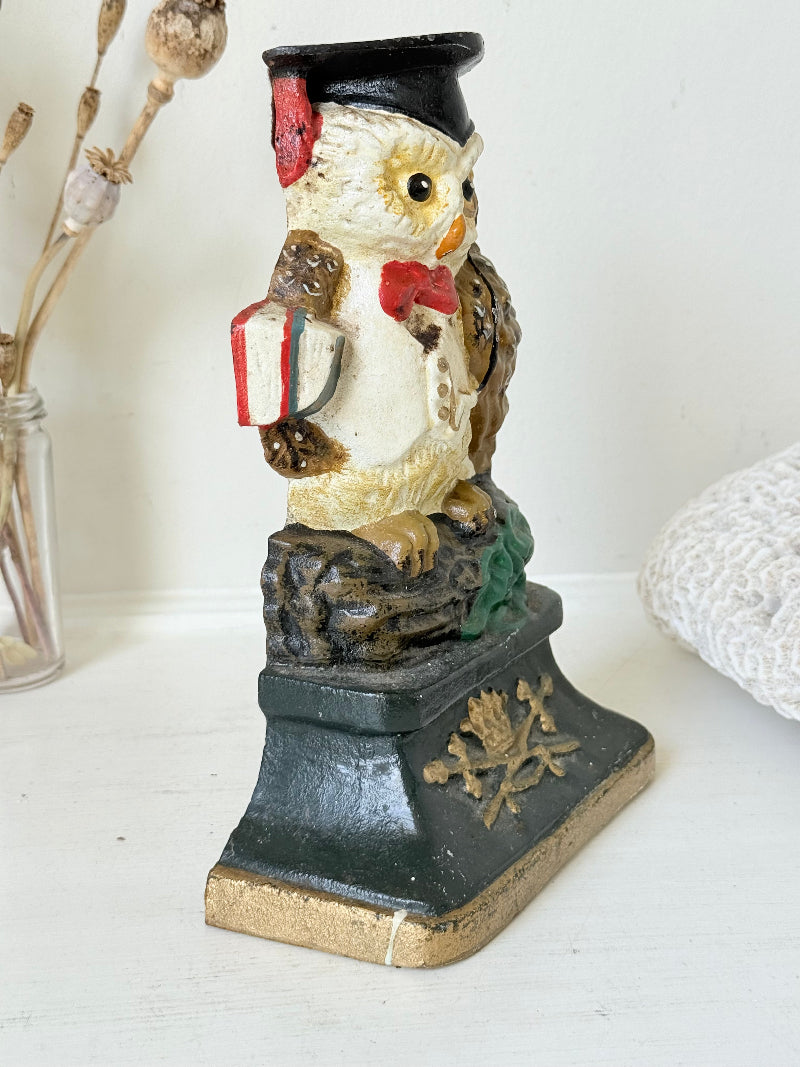 vintage hand painted cast iron owl doorstop with mortarboard and bow tie on white surface
