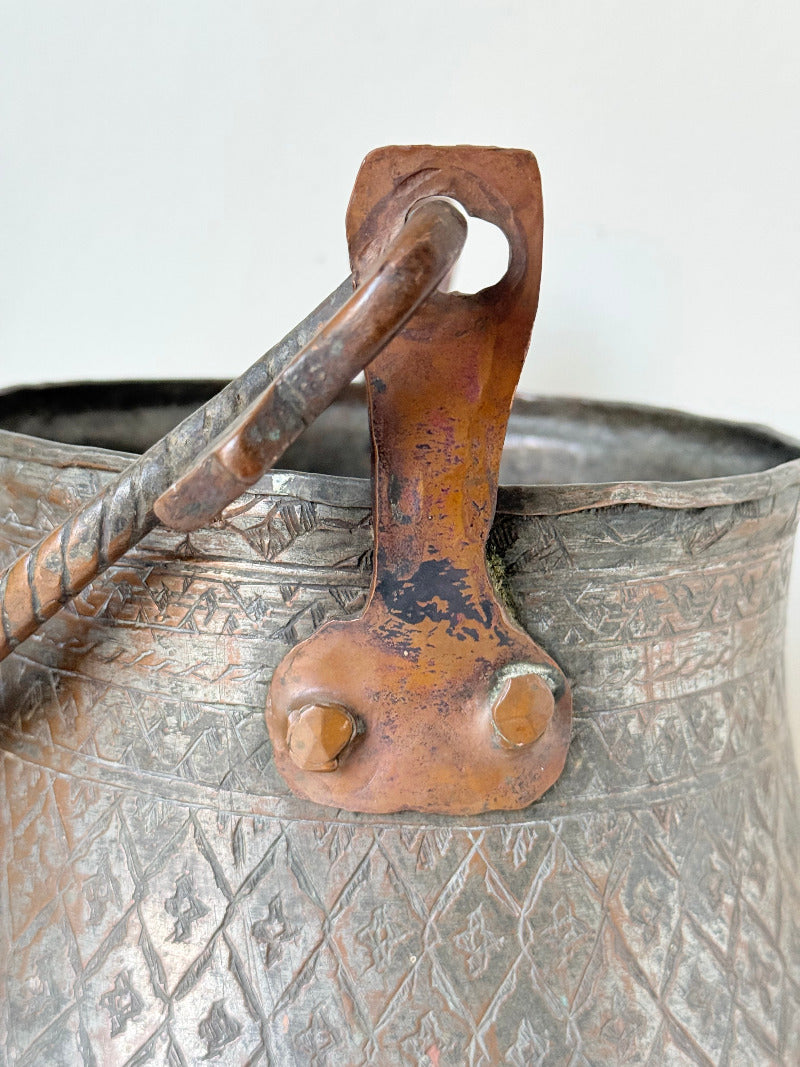 antique Middle Eastern water ewer with engraved diamond and foliate pattern and copper base, displayed on white surface