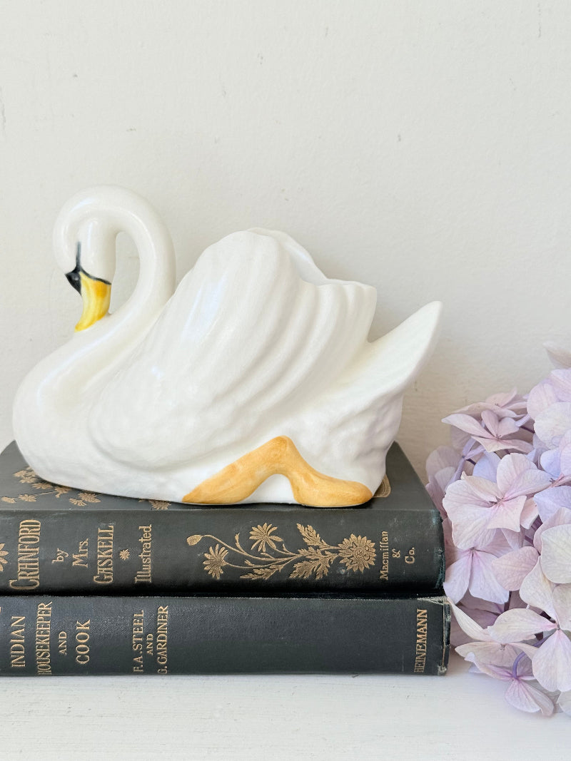 Vintage Sylvac swan planter in white ceramic with yellow beak and feet, styled on a white surface