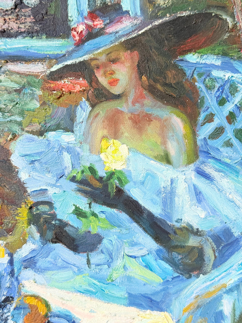 Framed impressionist-style oil painting of blue irises and garden scene, photographed on a white surface