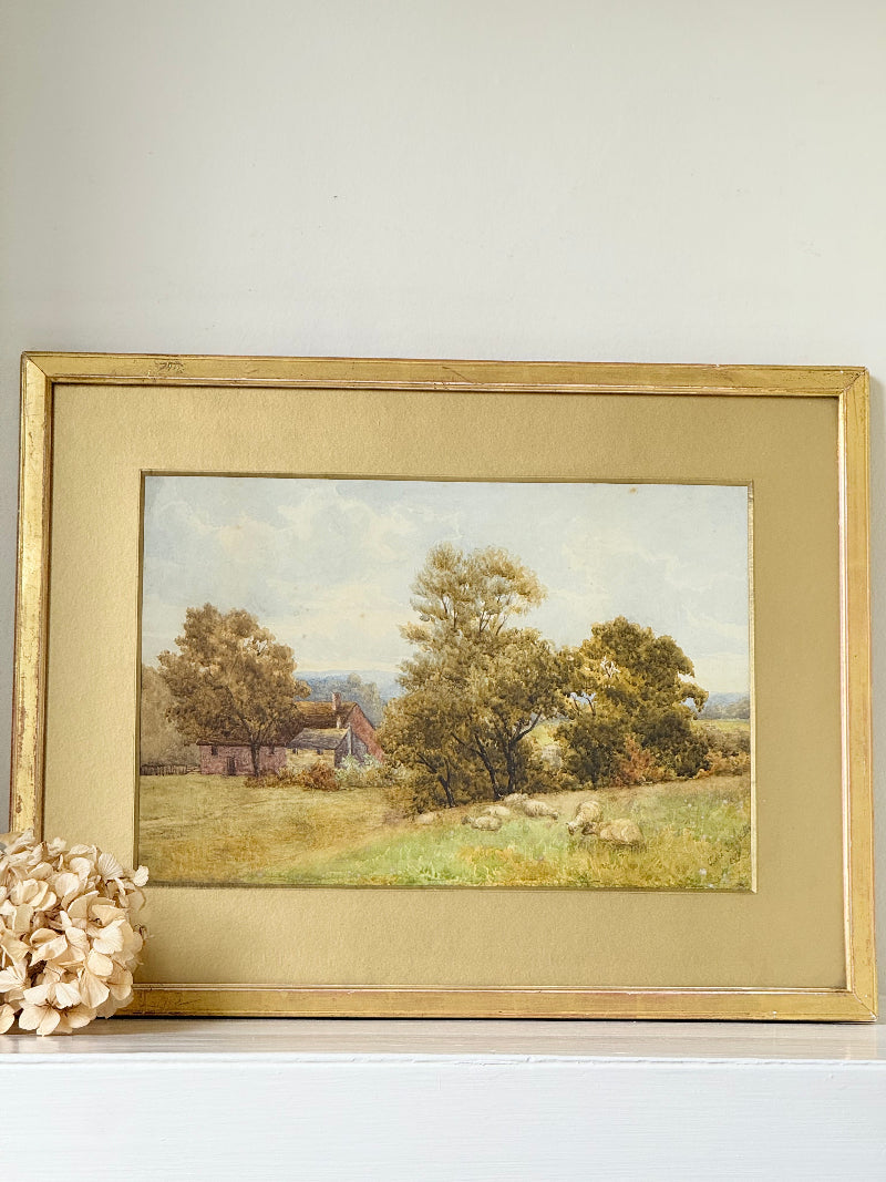 Antique watercolour landscape in gilt frame, countryside scene with trees, photographed on white surface.