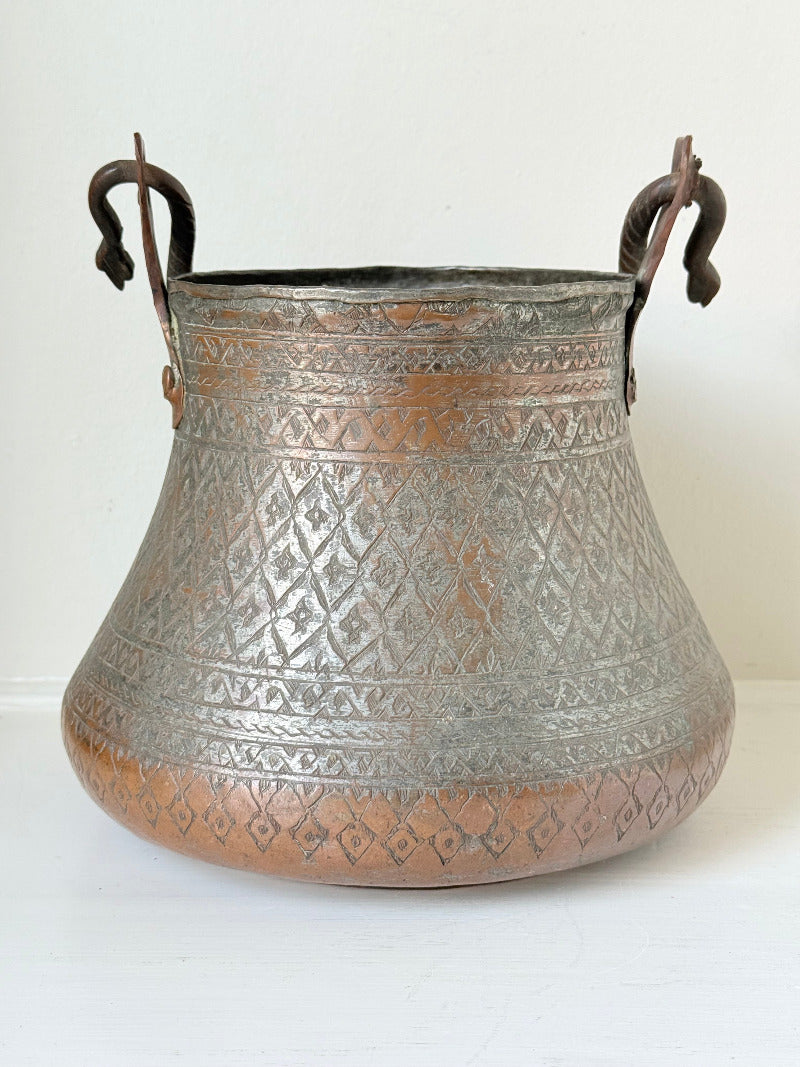 antique Middle Eastern water ewer with engraved diamond and foliate pattern and copper base, displayed on white surface
