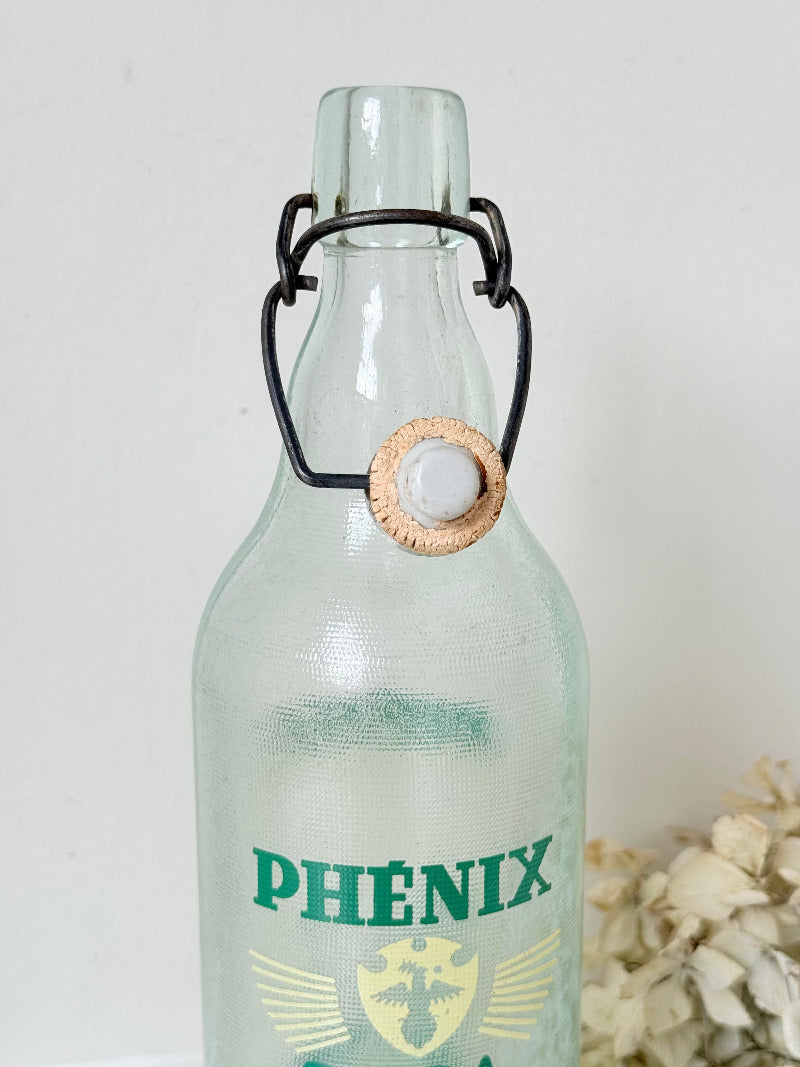 vintage french soda bottle phenix aqua green glass with ceramic swing top 31cm on white surface