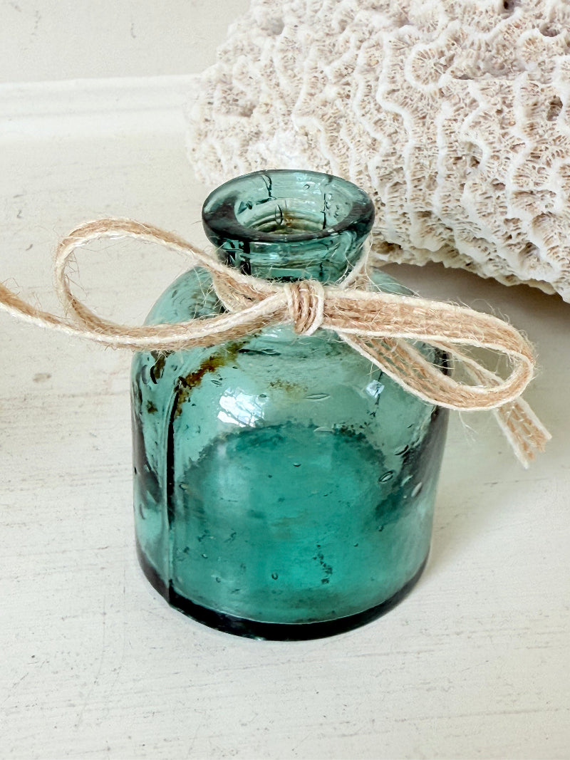 Set of antique green glass ink bottles with rounded forms, photographed on white surface.