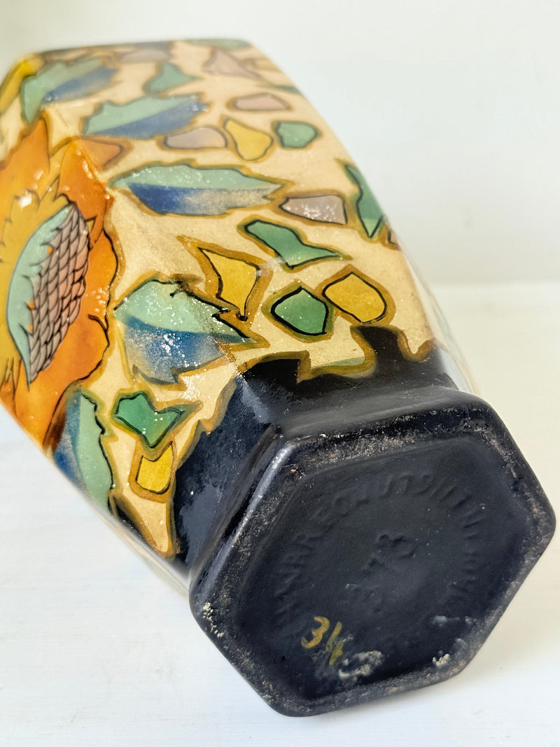 Art Deco Brentleigh Ware vase with hand painted floral design in orange, yellow, and teal on a black ground, photographed on a white surface