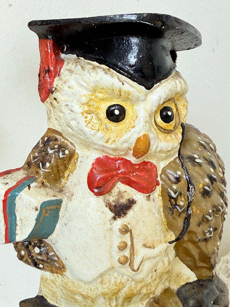 vintage hand painted cast iron owl doorstop with mortarboard and bow tie on white surface