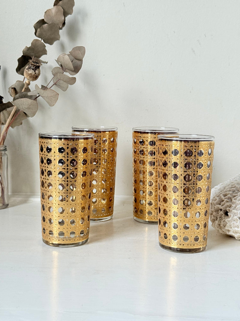 Set of 4 vintage gold rattan effect glasses with pierced lattice sleeves, photographed on a white surface