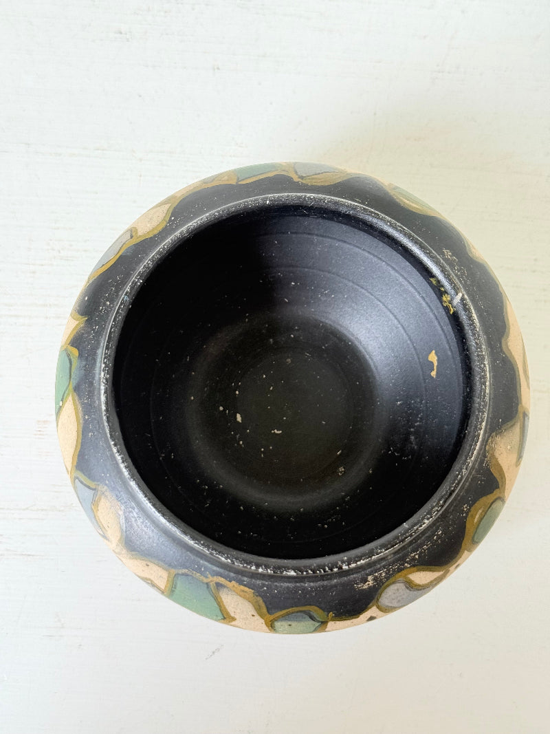 Brentleigh Ware Art Deco pottery jar with hand painted floral decoration on a black ground, photographed on a white surface