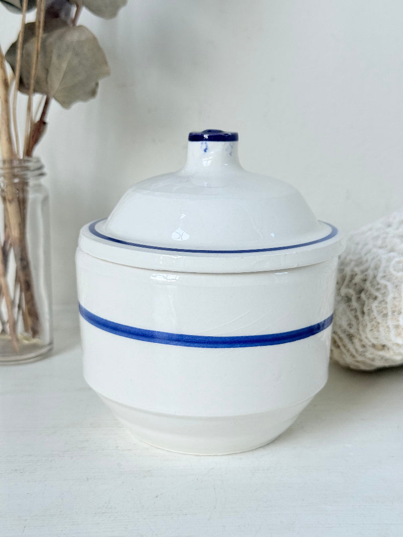 Vintage French blue and white studio pottery sugar bowl with lid, photographed on a white surface.