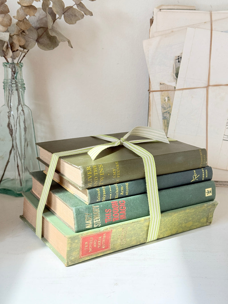 Bundle of vintage sage and olive green cloth books with red spine detail tied with a pale ribbon for styling