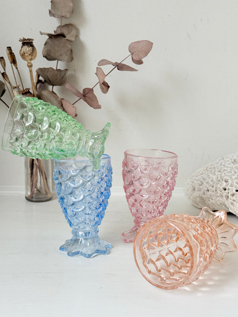 Set of 4 vintage pastel pressed glass mermaid goblets with textured scale pattern on a white surface