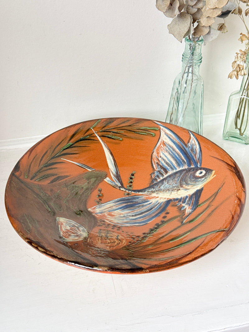 Mid century Puigdemont La Bisbal charger with hand painted fish in blue and white on orange glaze
