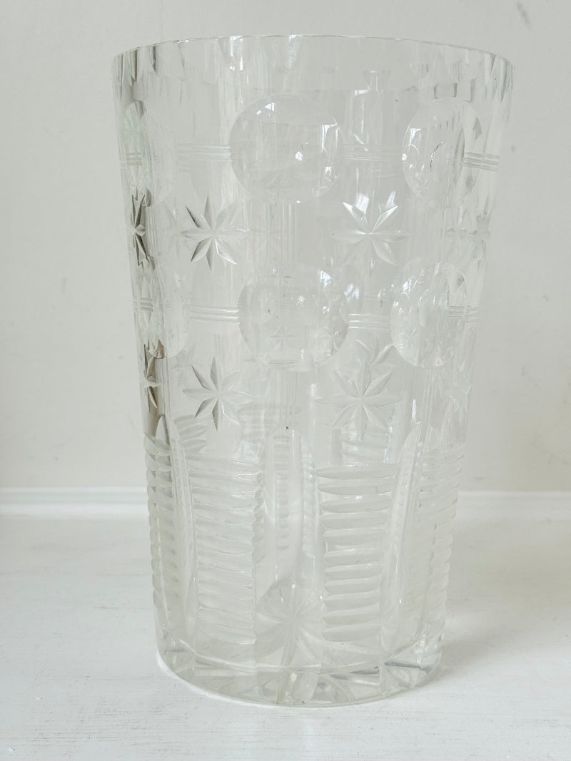 Vintage Stuart crystal cut glass vase with floral and star design, photographed on a white surface.