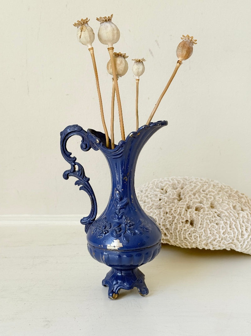 Blue vintage metal jug with ornate Rococo handle and relief decoration, shown on white background