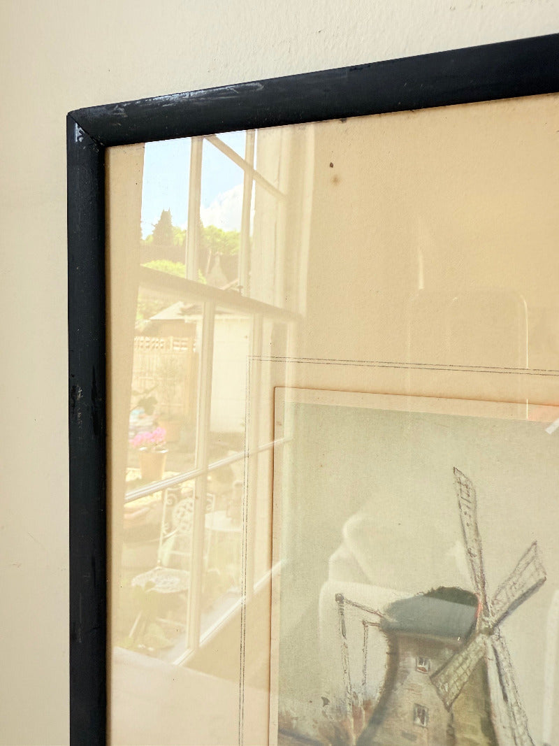 framed print of dutch windmill beside water in holland with reflection photographed on white surface
