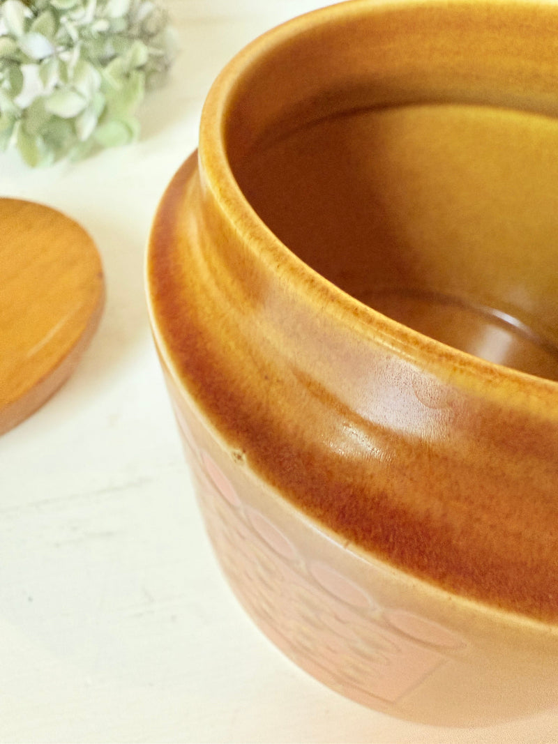 Vintage Hornsea kitchen canister in Saffron yellow with wooden lid photographed on a white surface.