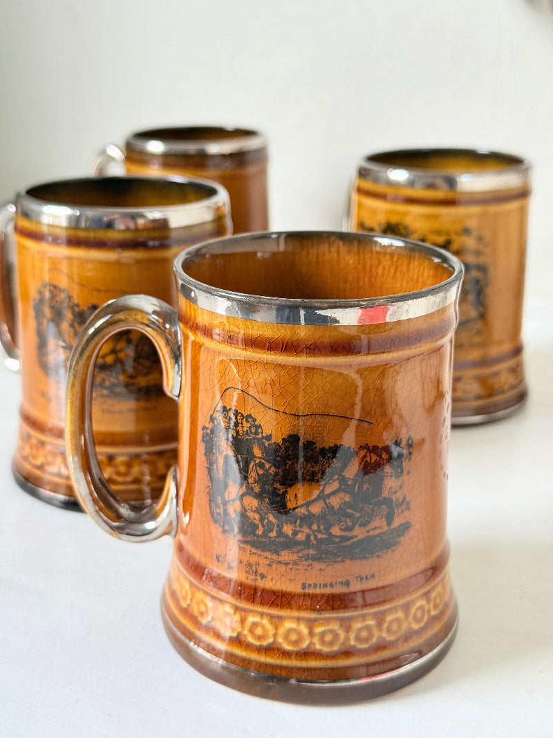 Set of 4 Ridgways stoneware tankard mugs photographed on a white surface in amber brown treacle glaze with black Coaching Days and Coaching Ways transfer scenes
