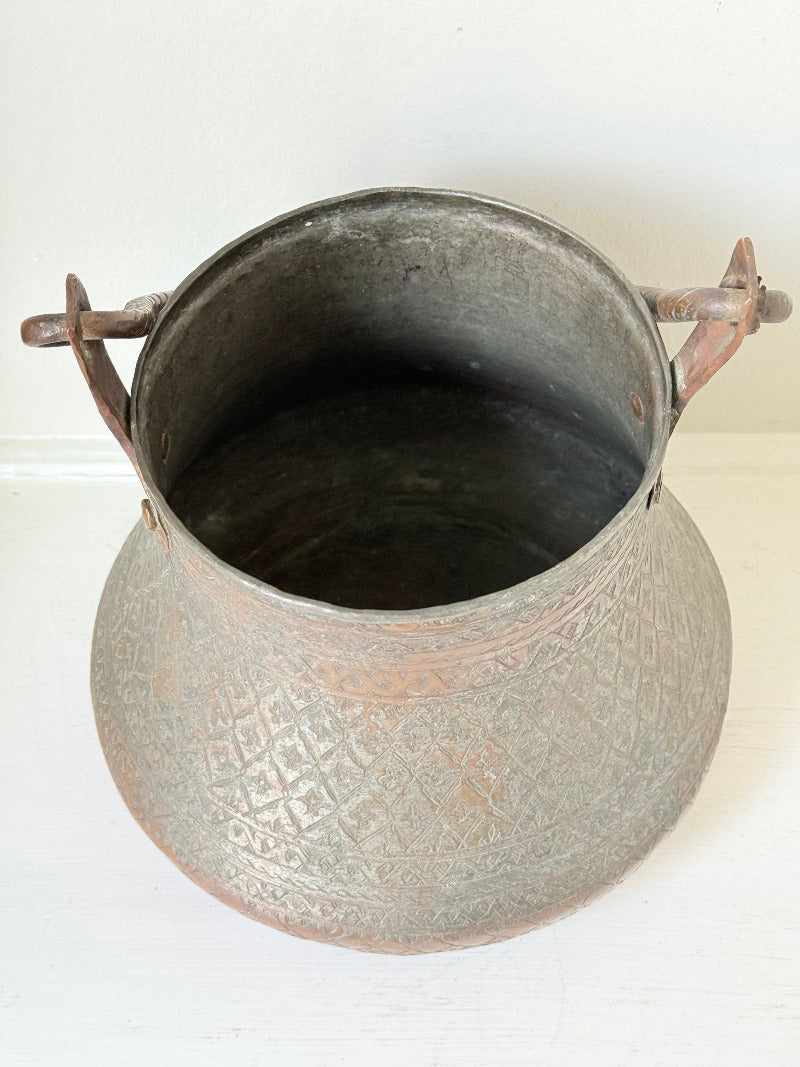 antique Middle Eastern water ewer with engraved diamond and foliate pattern and copper base, displayed on white surface