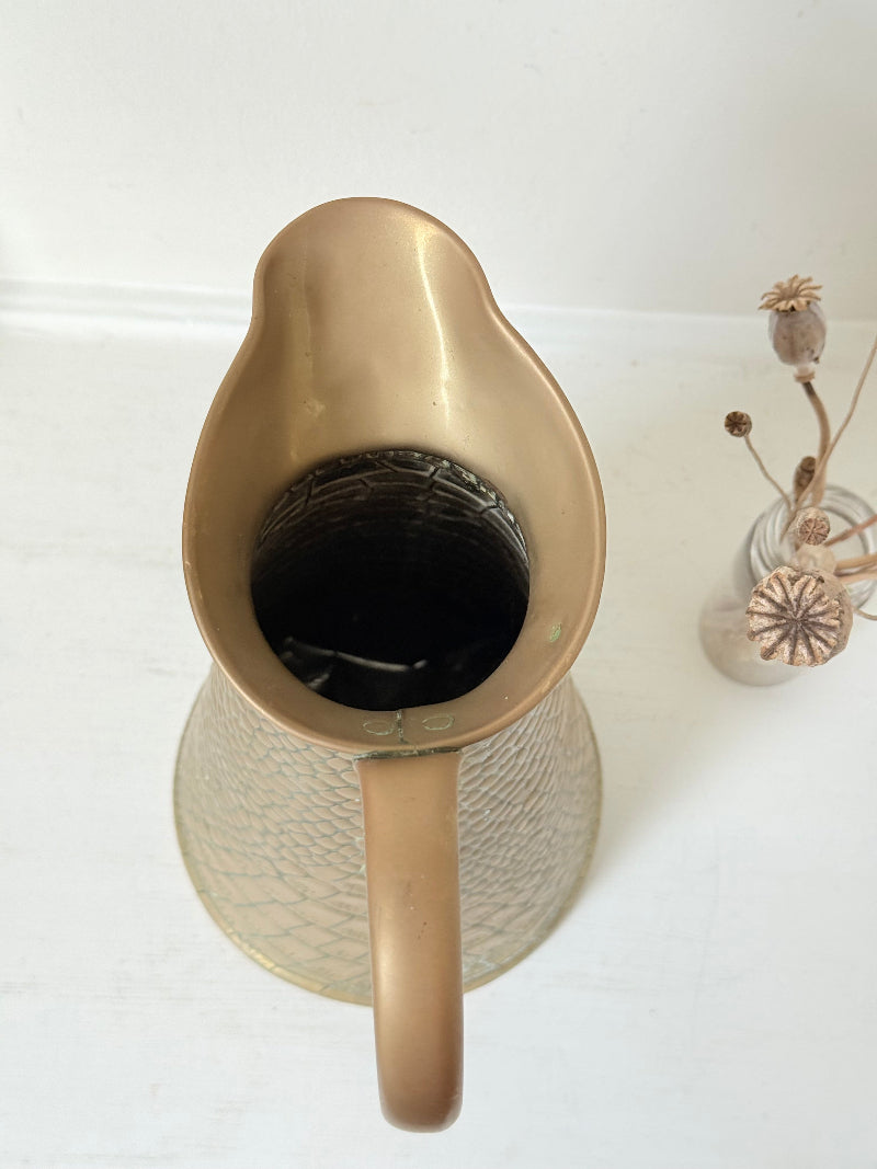 Vintage brass jug with alligator patterned surface, photographed against a white background.