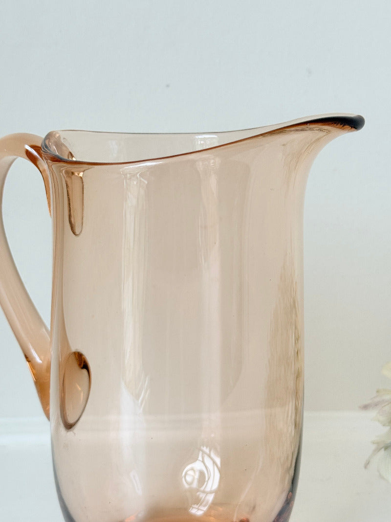 retro apricot glass serving jug with curved handle and flared spout, photographed on white surface