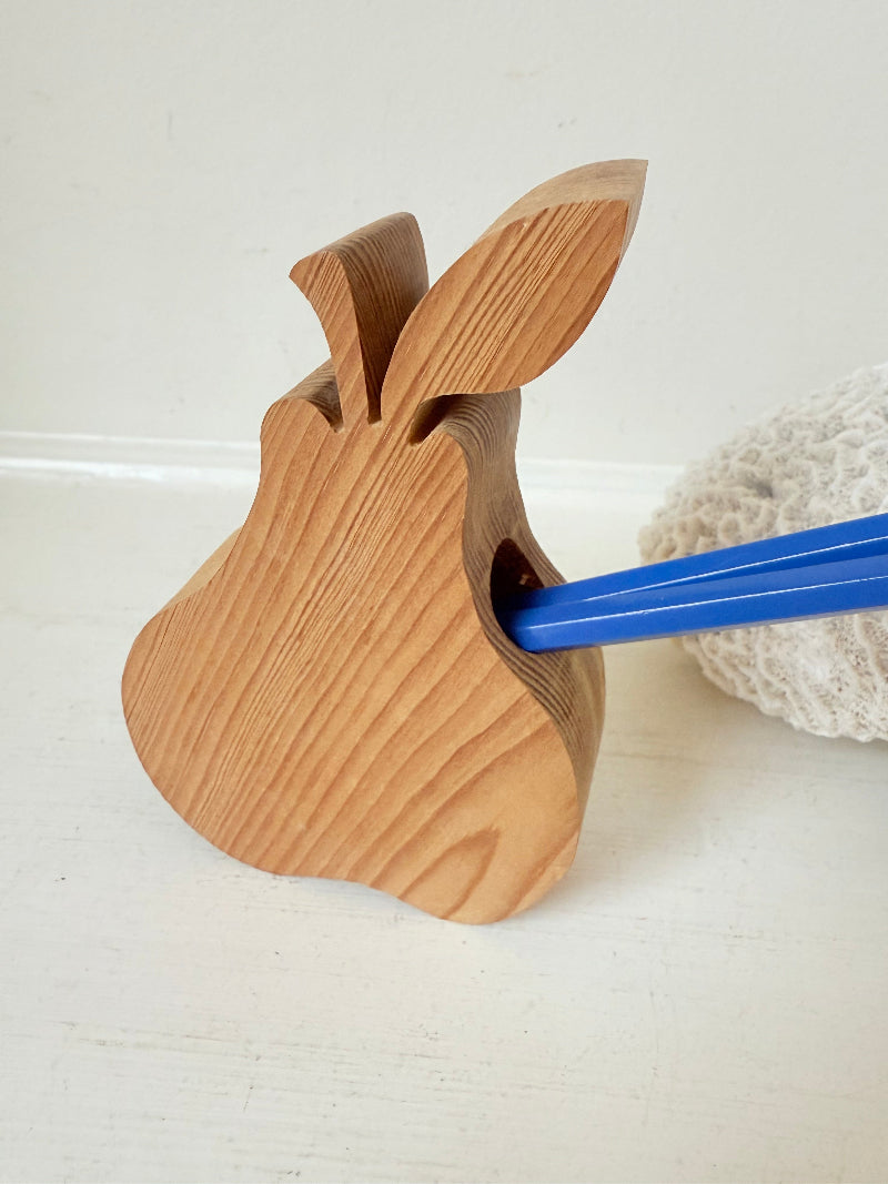 Vintage wooden pear sculpture in natural grain photographed on a white surface.