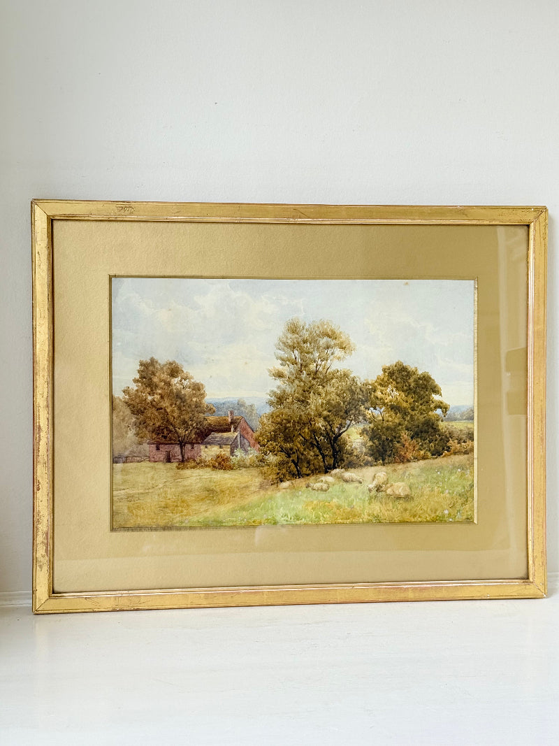 Antique watercolour landscape in gilt frame, countryside scene with trees, photographed on white surface.