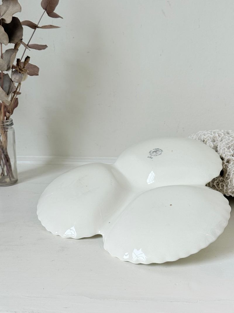 Poole Pottery double scallop hors d’oeuvre dish in white glaze with red handle photographed on a white surface