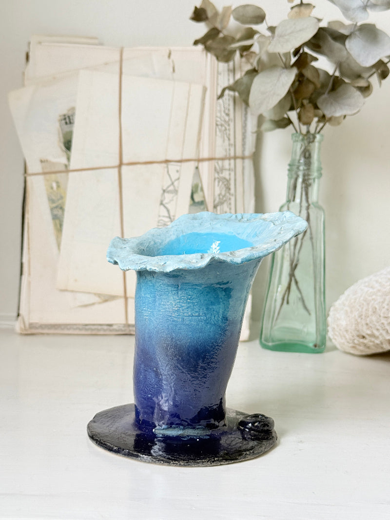Handmade studio pottery trumpet vase in ombre blue with a frilled rim, photographed on a white surface