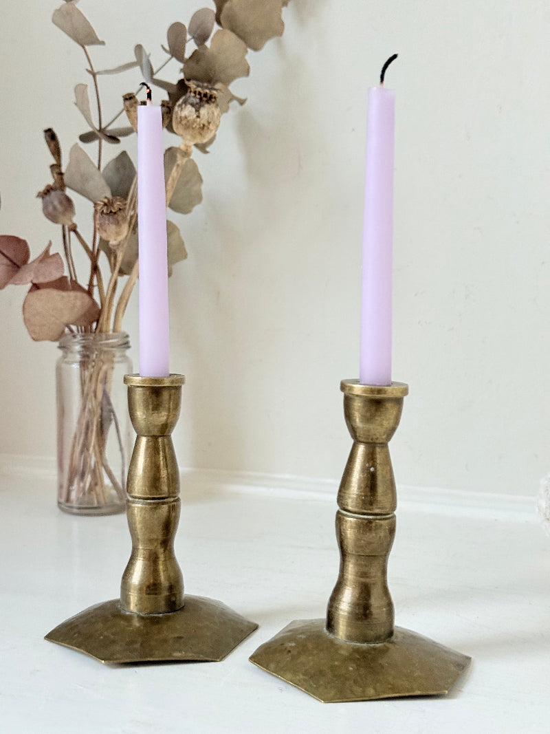 Pair of miniature brass candlesticks with hex bases photographed on a white surface