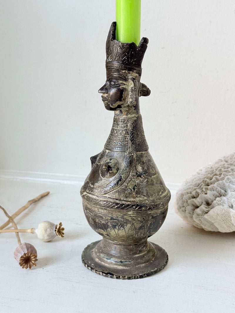 Antique Bengali anthropomorphic brass ritual vessel with goddess figure and lobed headdress, on a white surface