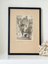 framed black and white print of edinburgh old town architecture photographed on white surface