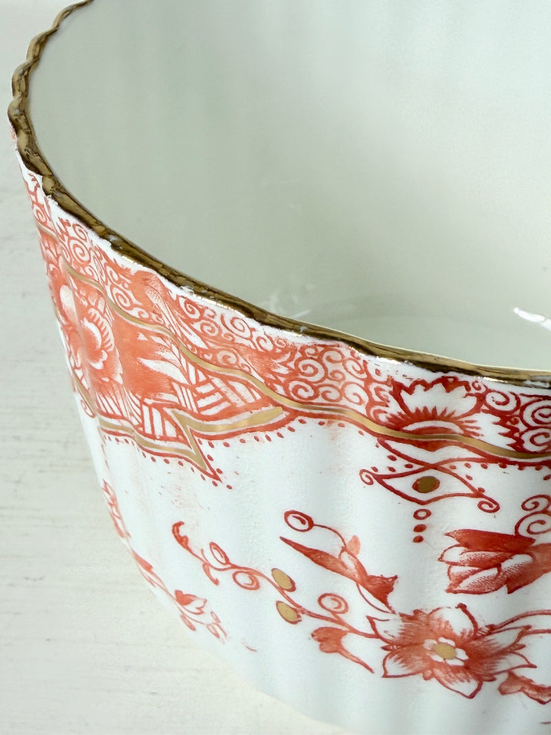 vintage porcelain sugar bowl with coral transfer design and gilt rim on white surface