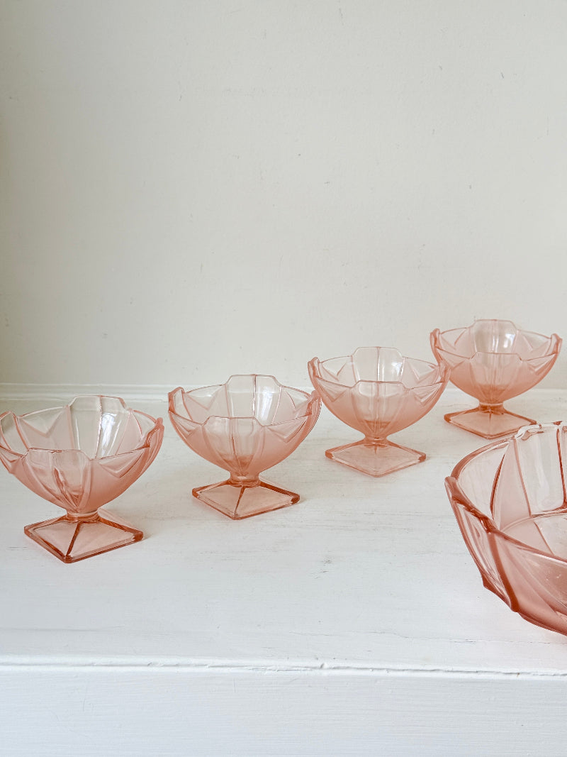Art Deco pink pressed glass dessert service with scalloped serving bowl and four footed sundae dishes