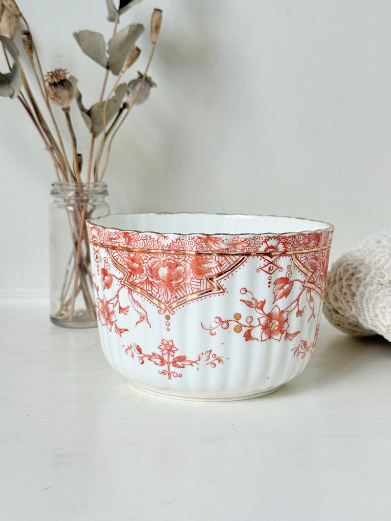 vintage porcelain sugar bowl with coral transfer design and gilt rim on white surface