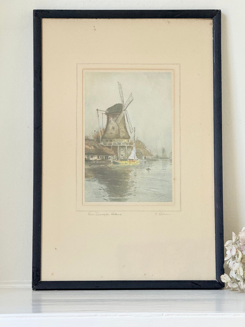 framed print of dutch windmill beside water in holland with reflection photographed on white surface