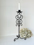 Vintage metal candlestick with scrollwork design and tripod base, 40 cm tall, styled with white taper candle.