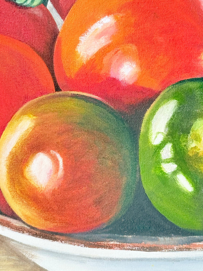 Close-up of red, green, and orange round tomatoes on a textured surface.